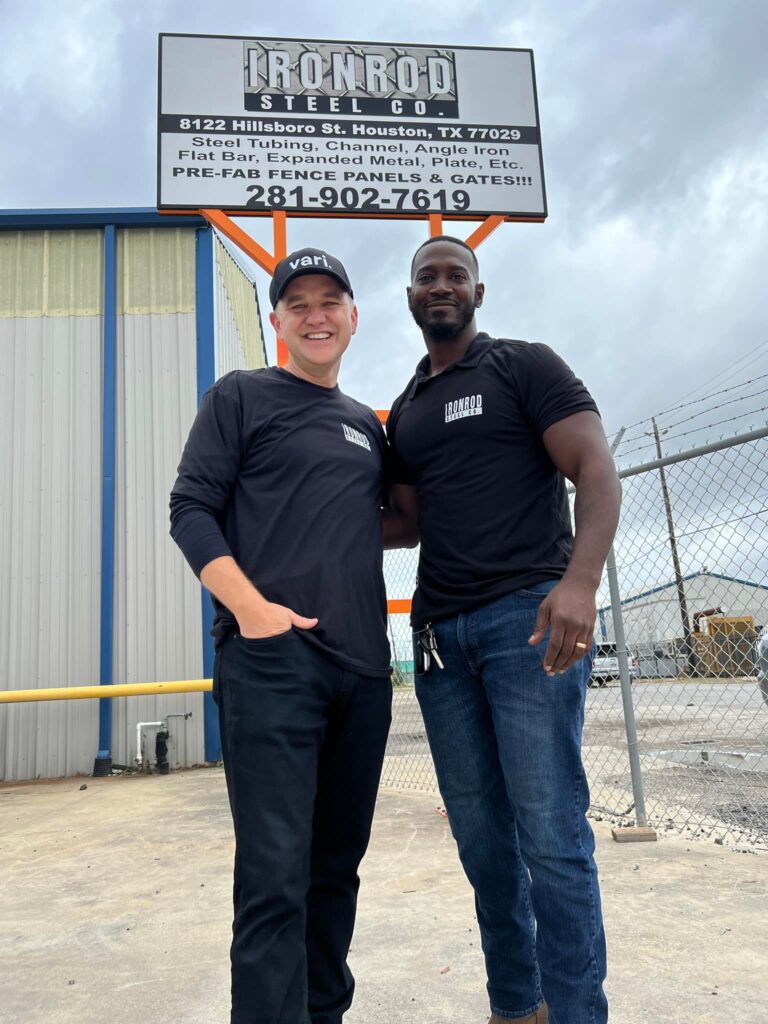 PEP graduate and supporter standing outside Iron Rod Steel Company celebrating business success