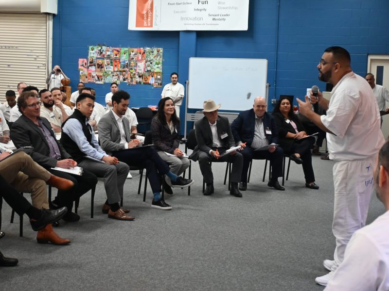 PEP participant delivering business pitch to panel of volunteer judges during program event