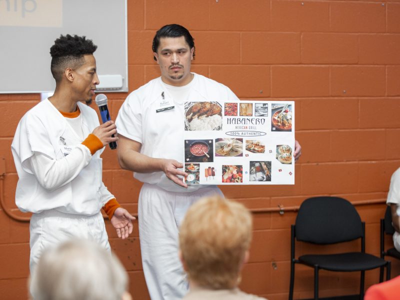 PEP participants presenting a business pitch with visual board during program event