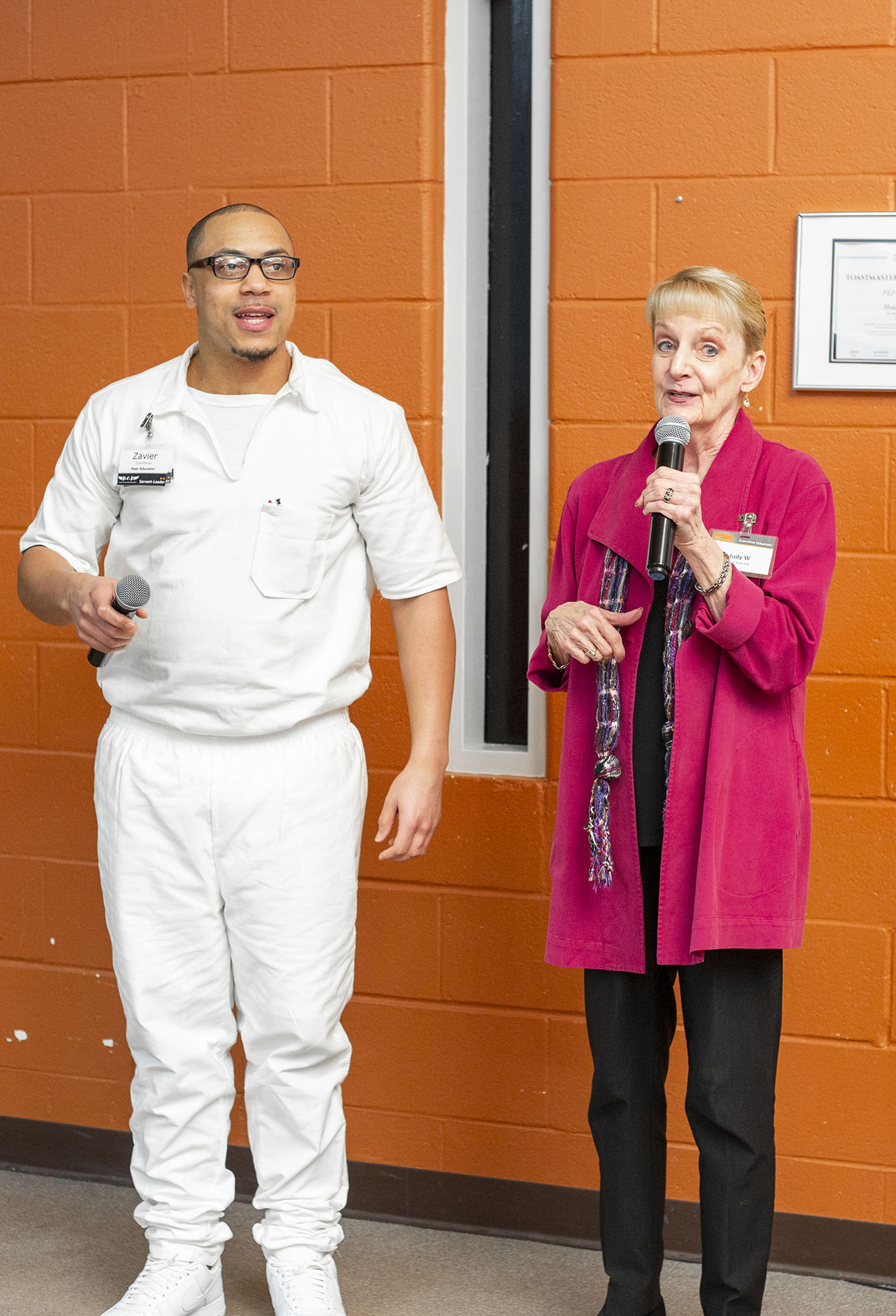 PEP participant and volunteer speaking together with microphones during a prison event