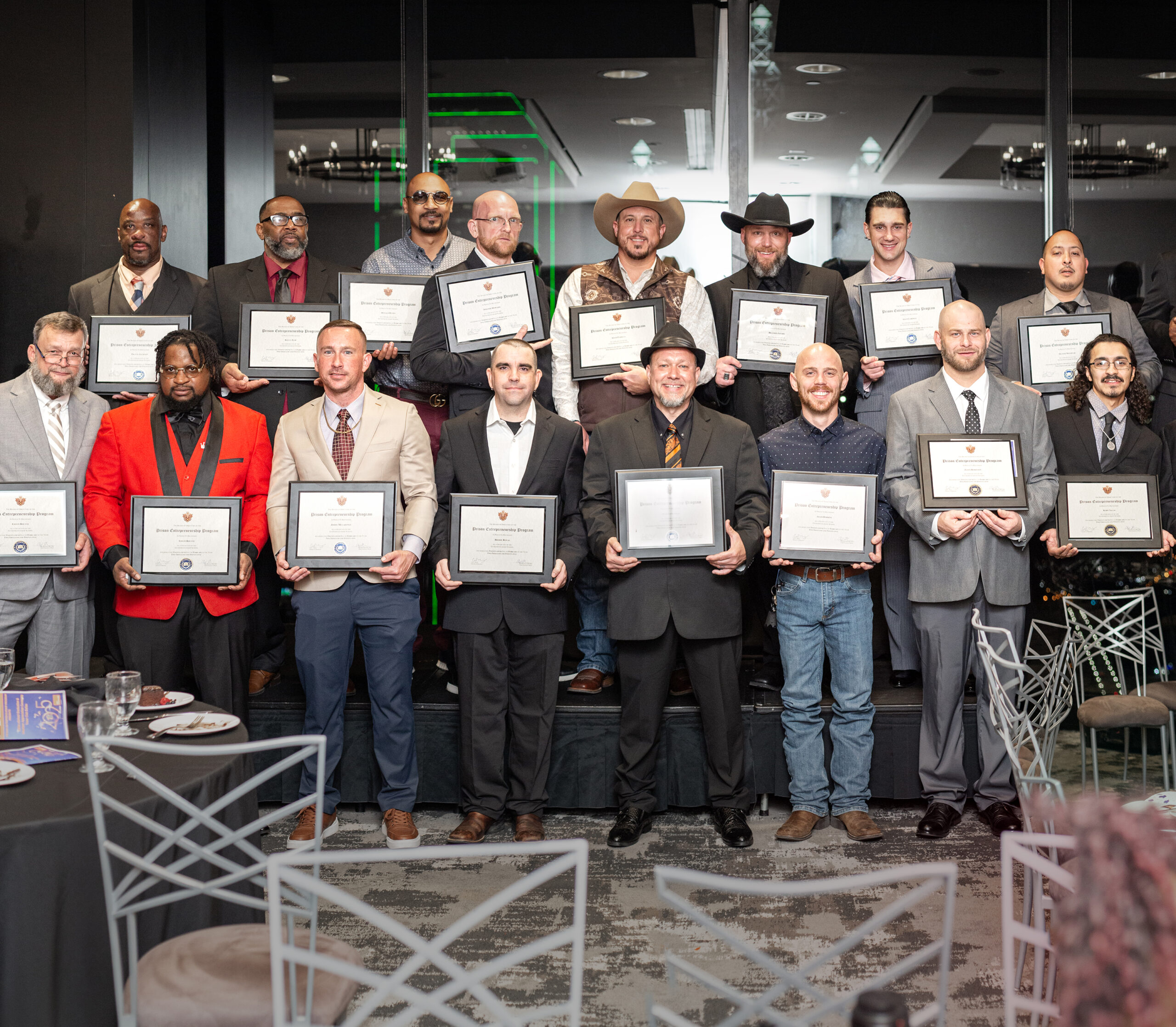Group of PEP graduates proudly holding framed certificates at completion ceremony